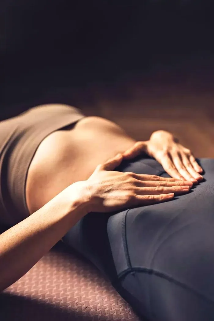 Hands resting on a woman's abdomen during bodywork
